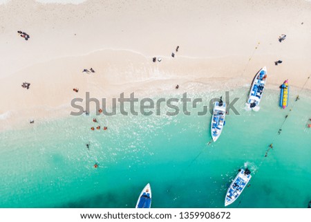 aerial shot of people and boat in waves and sand on beach in Phuket Island,Thailand