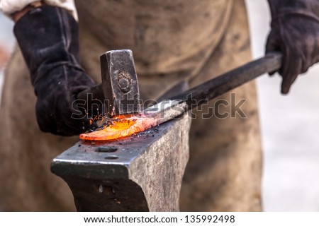 Blacksmith working on metal on anvil at forge high speed detail shot Royalty-Free Stock Photo #135992498