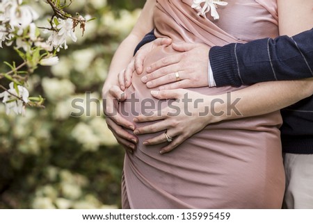 Mom and Dad with hands on the baby