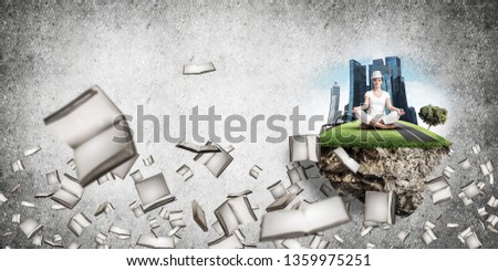 Woman in white clothing keeping eyes closed and looking concentrated while meditating on island in the air among flying books with gray wall on background. 3D rendering.