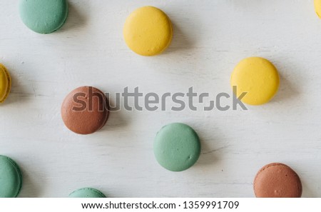 Many macarons on white wooden background. Top view. View from above