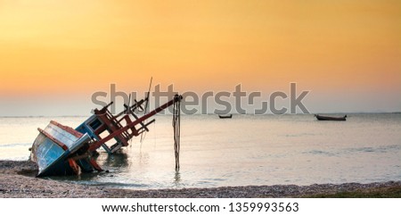 Old shipwreck boat on beach with silhouette sunset background landscape scene. wrecked ship at Hat Krathing Lai Seashore Park. Sukhumvit Pattaya, Thailand. Thai letters mean Good luck or Safe travel
