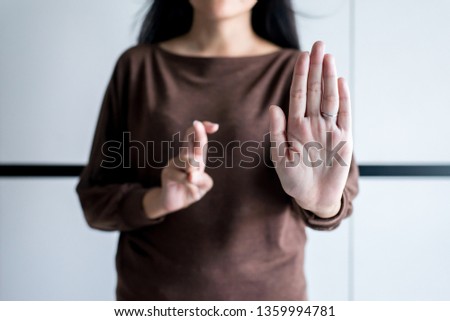 Woman showing hand stop and blured lie crossing fingers telling liar, April Fools' Day concept