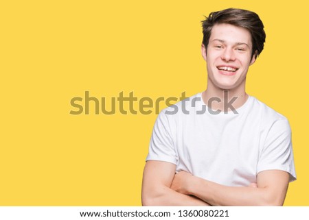 Young handsome man wearing casual white t-shirt over isolated background happy face smiling with crossed arms looking at the camera. Positive person.