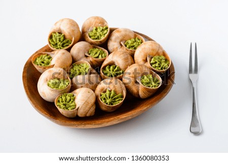 Large Escargots de Bourgogne Snails baked with garlic butter on light background. Healthy food concept with copy space.
