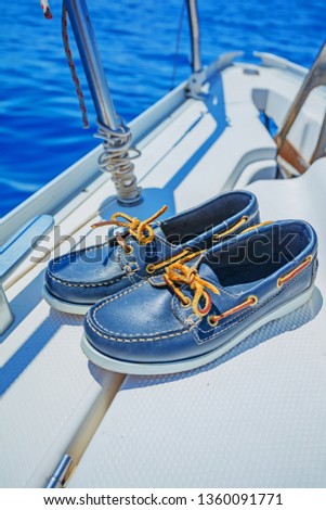 A pair of blue topsider on white yacht deck. Yachting