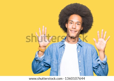 Young african american man with afro hair showing and pointing up with fingers number ten while smiling confident and happy.