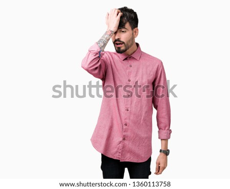 Young handsome man wearing pink shirt over isolated background surprised with hand on head for mistake, remember error. Forgot, bad memory concept.