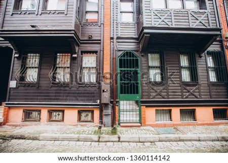 Historic street with wooden houses in Istanbul, Turkey. Colorful houses in the Mediterranean style, cozy narrow streets, ancient doors and windows, potted plants.