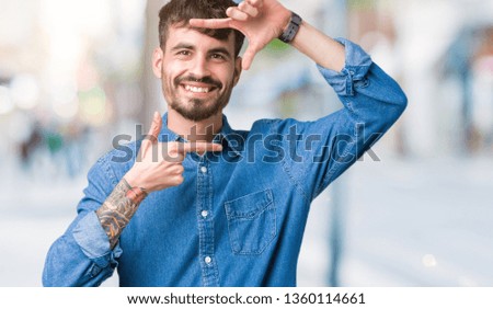 Young handsome man over isolated background smiling making frame with hands and fingers with happy face. Creativity and photography concept.