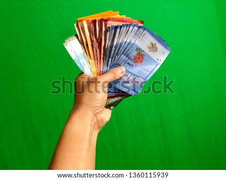 hand holding Malaysia money with green background