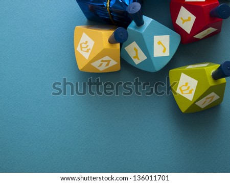Colorful dreidels with presents on blue background.