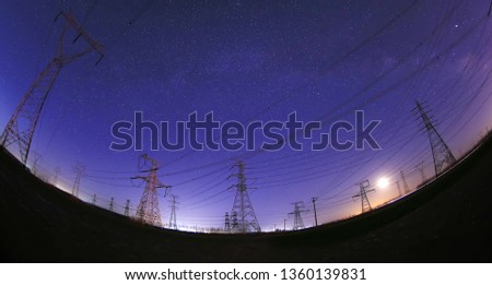 At night, the high voltage tower and substation, in a beautiful starry sky background