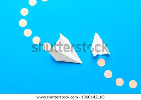 Flat lay of white paper plane and blank paper on pastel blue color background