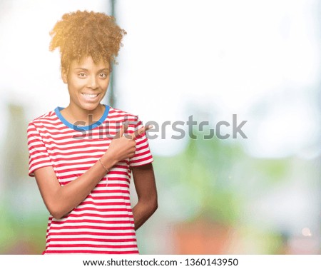 Beautiful young african american woman over isolated background cheerful with a smile of face pointing with hand and finger up to the side with happy and natural expression on face