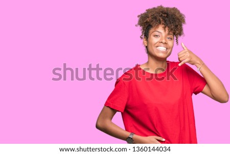 Beautiful young african american woman over isolated background smiling doing phone gesture with hand and fingers like talking on the telephone. Communicating concepts.