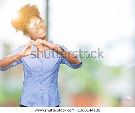 Beautiful young african american business woman over isolated background smiling in love showing heart symbol and shape with hands. Romantic concept.