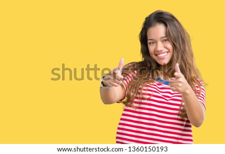 Young beautiful brunette woman wearing stripes t-shirt over isolated background pointing fingers to camera with happy and funny face. Good energy and vibes.
