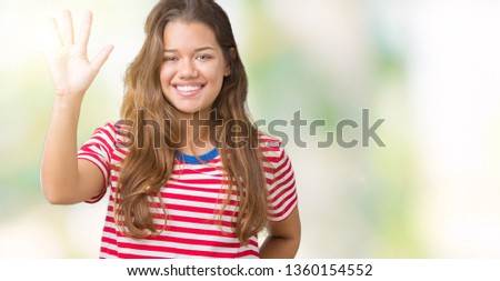 Young beautiful brunette woman wearing stripes t-shirt over isolated background showing and pointing up with fingers number five while smiling confident and happy.