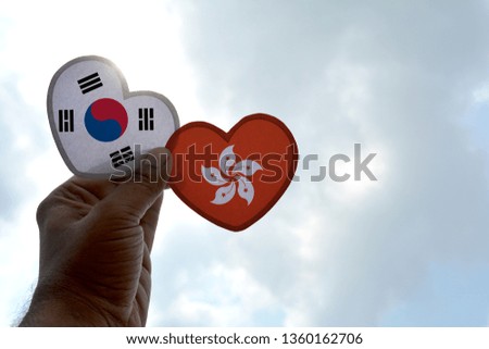 Hand holds a heart Shape South Korea and Hong Kong flag, love between two countries