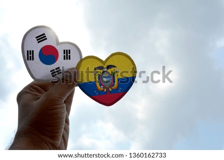 Hand holds a heart Shape South Korea and Ecuador flag, love between two countries