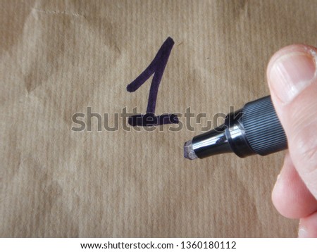 the number 1 (one) writed on wrapping paper employing a black/blue felt tip pen Royalty-Free Stock Photo #1360180112