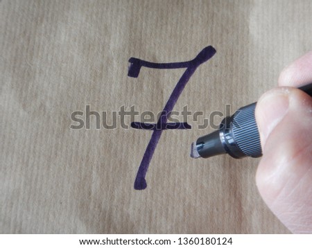 the number 7 (seven) writed on wrapping paper employing a black/blue felt tip pen Royalty-Free Stock Photo #1360180124