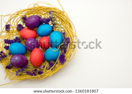 Colored chicken eggs in nest on white background. Preparing celebrating Easter