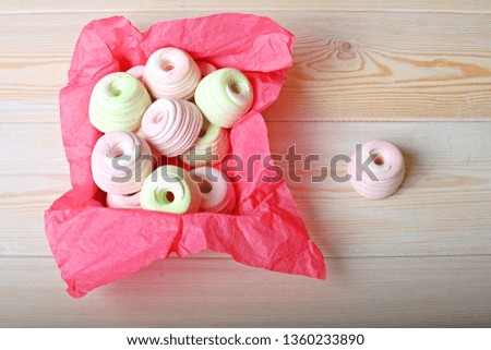 Sweet box with zephyr marshmallow on pink paper wooden background with copy space