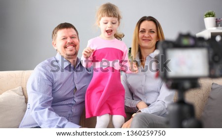 Young happy family sit on couch making photo session portrait looking at camera