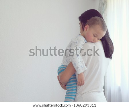 Portrait baby boy sleeping on mother's shoulder.Mother's day. Vintage photo mom and son. Isolated on white background.