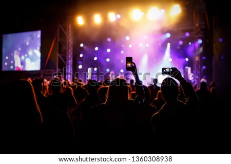 Hands with a smartphone records live music festival, Taking photo of concert stage, live concert, music festival, happy youth, luxury party.