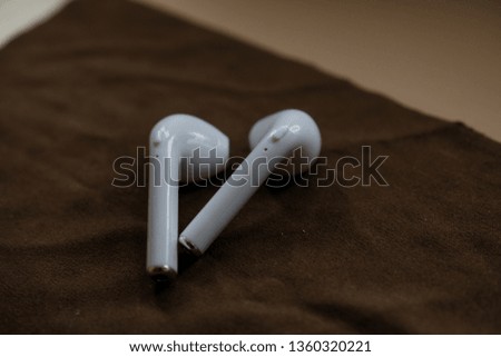 wireless earphones on a brown cloth