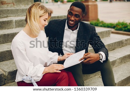The guy and the girl are working. A couple sitting on the stairs. People with a notebook