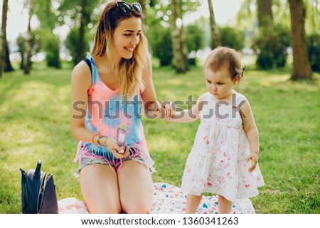 Mom and daughter. The family is resting. Little girl in the park with mom