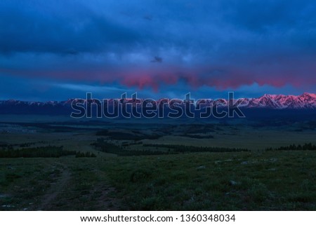 Colorful dawn with beautiful clouds on the sky and a dirt rocky road in the mountains