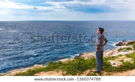Man stands on the edge of the abyss and looks at the sea