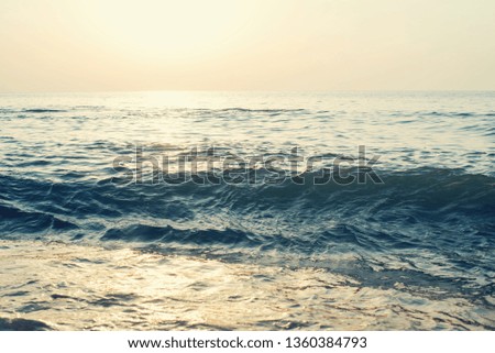 Waves on beach at sunset, toned
