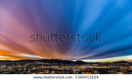Time blend of a day to night shot over a small mountain town with an epic sunset.