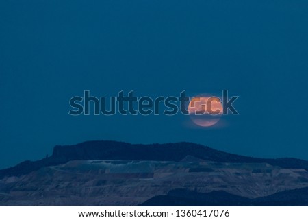 A supermoon rises over an iconic mountain in the southwest. 