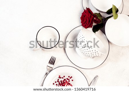 Valentines day dinner top view white plate red rose and hearts confetti