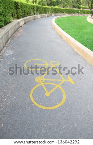 Yellow bicycle sign on curve park road.
