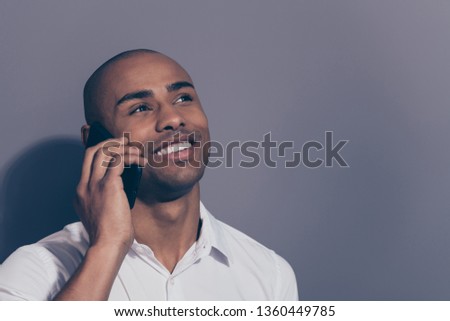 Close up photo amazing dark skin he him his macho hold hand arm telephone smart phone speak tell say communicate relatives friends look up empty space toothy wear white shirt isolated grey background