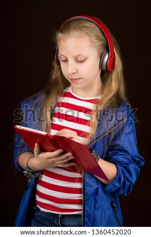 girl in jeans and jacket with headphones and tablet computer