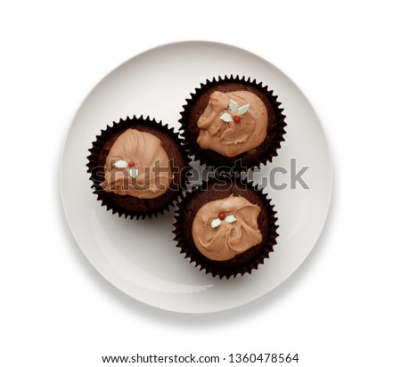 Cut out image of a white plate with  3 chocolate fairy cakes, and a drop shadow