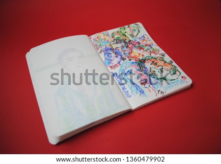 Drawings in a notebook. Lines of different colors. Drawings of people's faces. Red background. Small notebook with drawings. Portraits of people