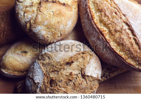 top view closeup detail of different types of bread texture crust on wooden kitchen cutting board in natural light shallow depth of field