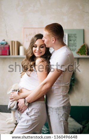 Husband hugs his pregnant wife. Stylish photo in anticipation of a miracle