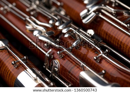 Wooden bassoon isolated on a black background. Music instruments. Royalty-Free Stock Photo #1360500743