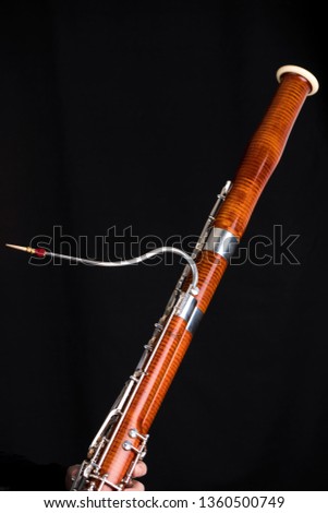 Wooden bassoon isolated on a black background. Music instruments. Royalty-Free Stock Photo #1360500749
